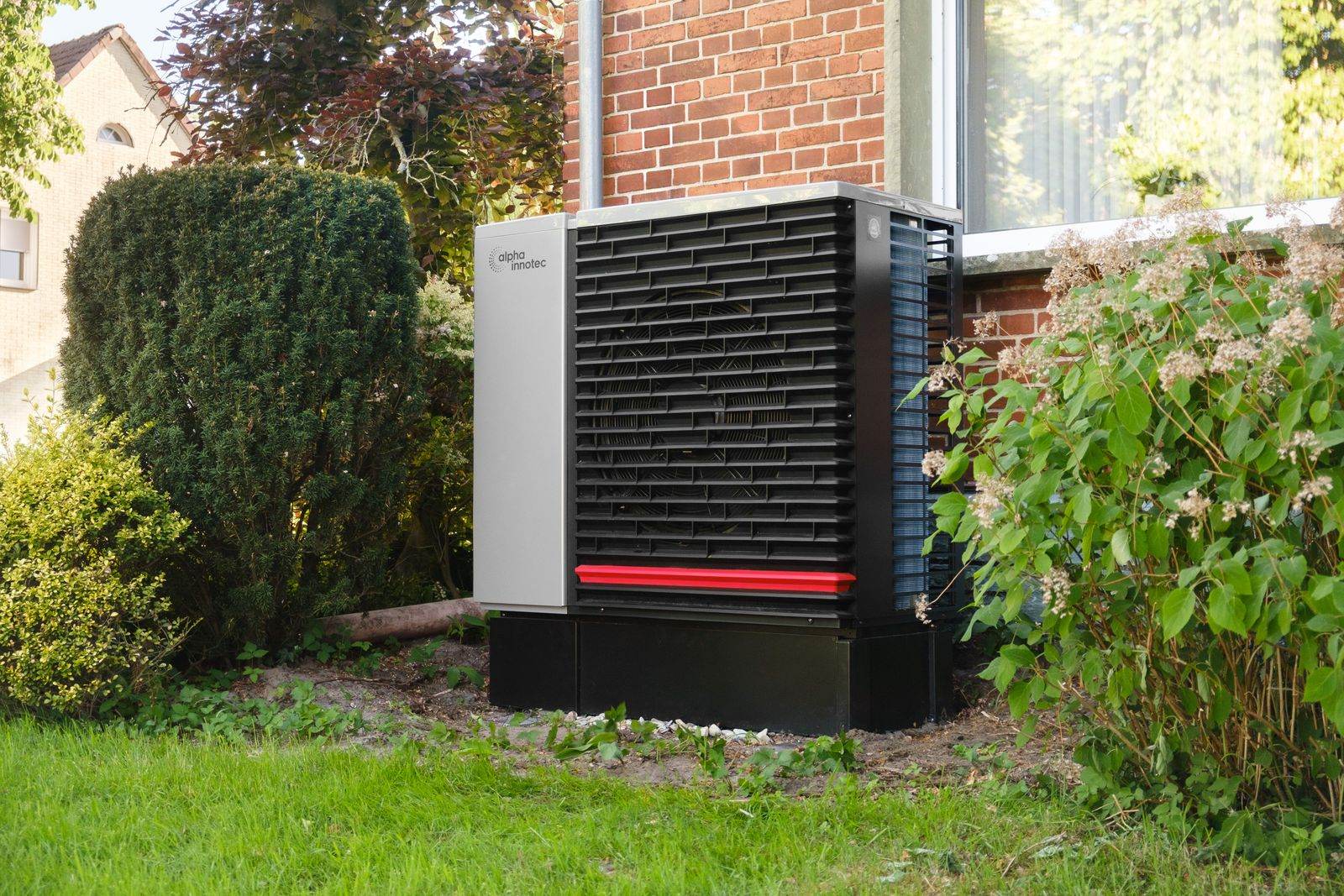 Wärmepumpe an einem Wohnhaus mit Garten